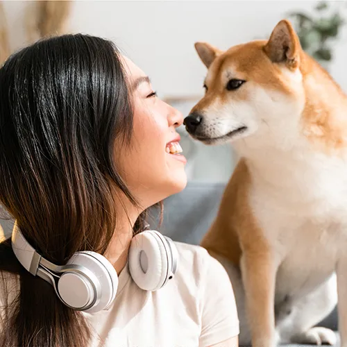 Smiling woman and dog looking at each other