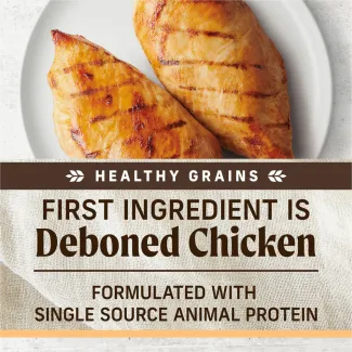 A topdown photo of cooked chicken breasts on a white plate; text below reads "healthy grains. First ingredient is deboned chicken. Formulated with single source animal protein"